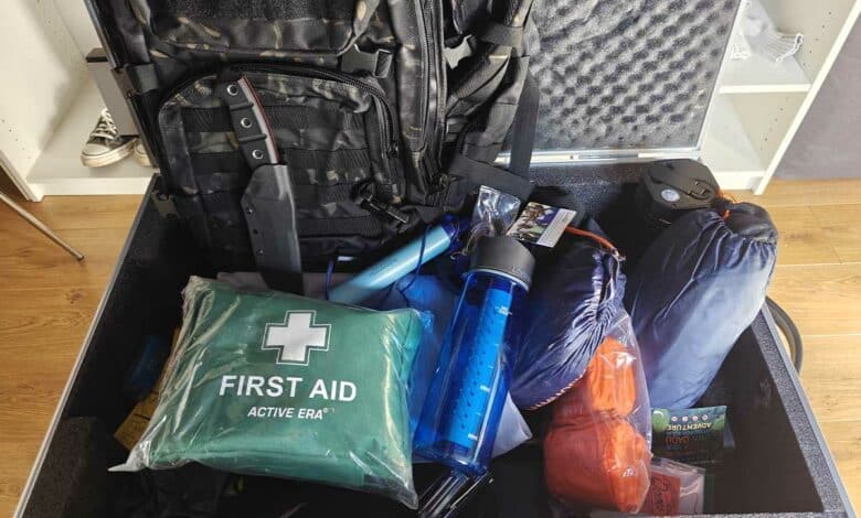 Un kit d'urgence avec une trousse de soins, des gourdes filtrantes, un panneau solaire et un couteau de survie.