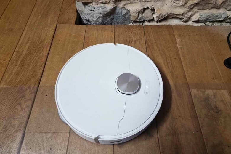 Un aspirateur robot sur du parquet.