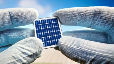 Une cellule photovoltaïque tenue entre les mains.