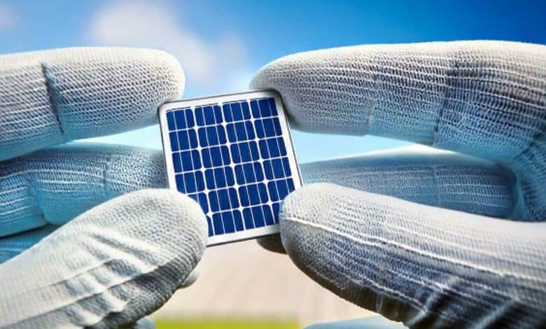 Une cellule photovoltaïque tenue entre les mains.
