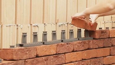 Une femme construit un mur en brique avec Facadeclick.