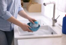 Une personne fait la vaisselle à la main.