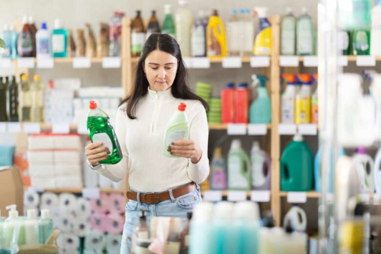 Une femme choisit des produits de nettoyage.