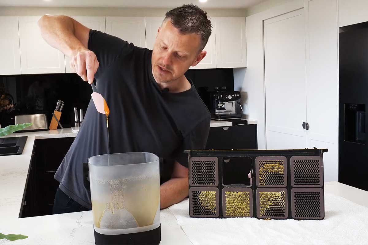 Un homme extrait son miel directement dans la machine.