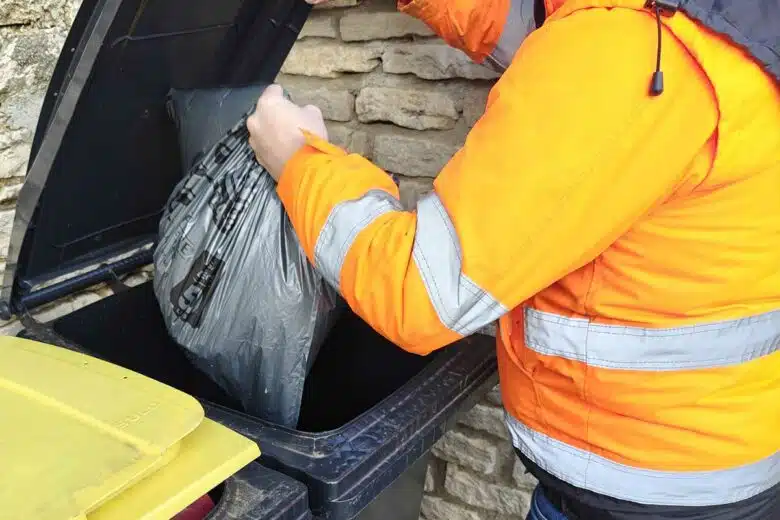 Une personne jette une poubelle.