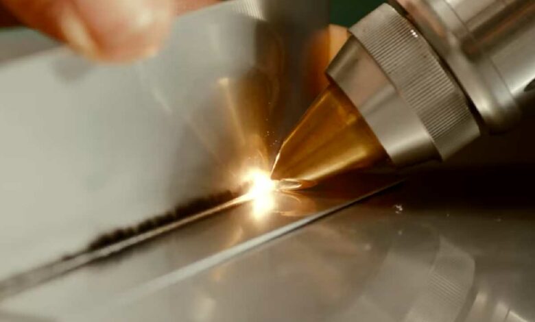 Un poste à souder laser multifonctions utilisé par un homme.