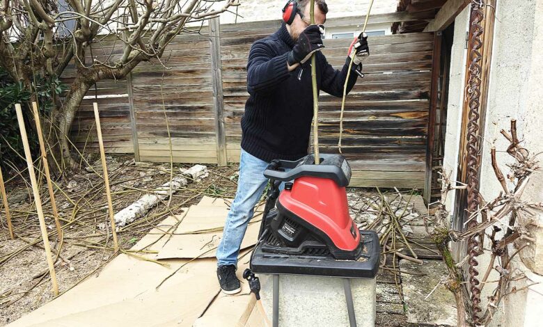Un homme utilise un broyeur de végetaux.
