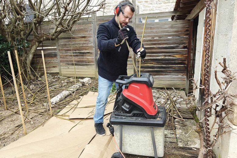 Une personne broie ses déchets verts.