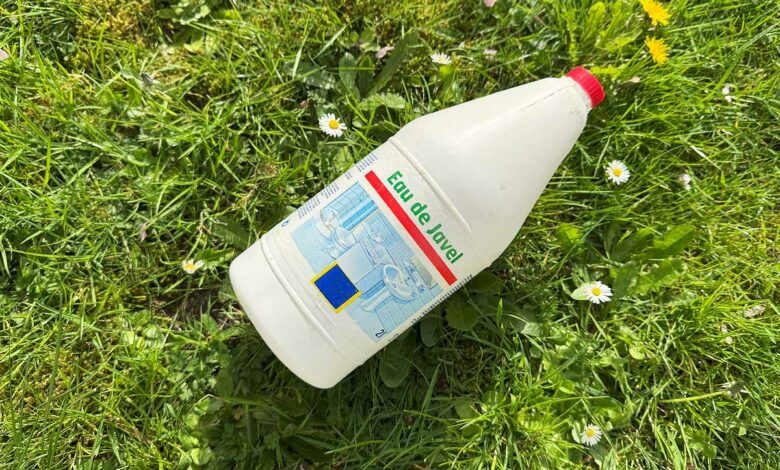 Un bidon d'eau de javel sur l'herbe.