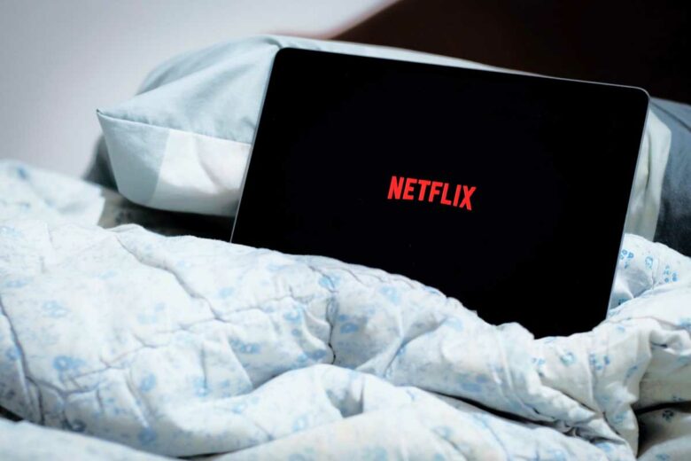 Une tablette avec Netflix dans un lit.