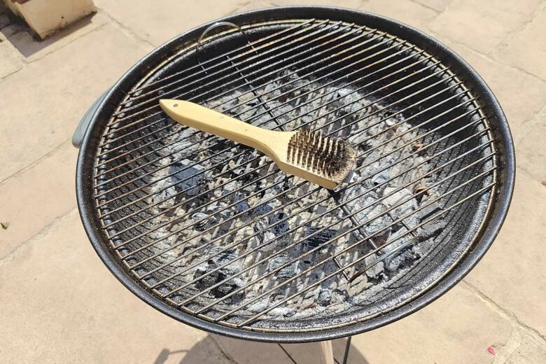 Brosse métallique sur la grille du barbecue.