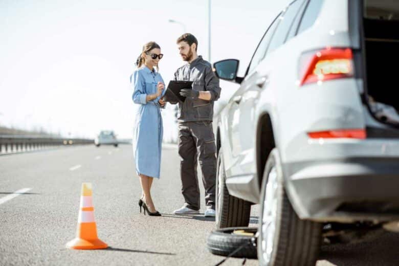 Une femme en panne sur le bord de la route.