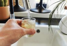 Une personne se verse un verre d'eau du robinet.