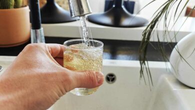 Une personne se verse un verre d'eau du robinet.