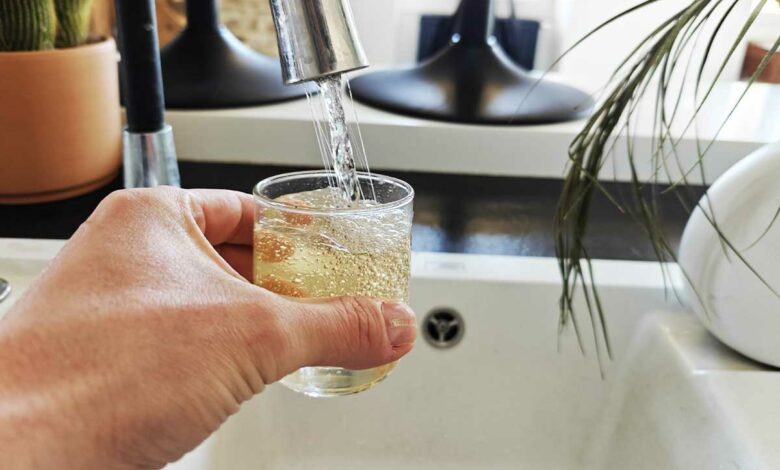 Une personne se verse un verre d'eau du robinet.