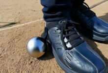 Un système aimanté qui se fixe à la chaussure pour relever une boule de pétanque.