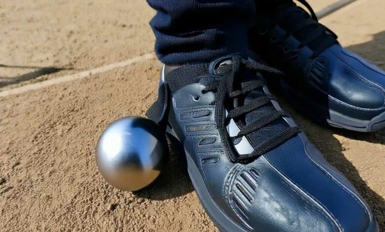 Un système aimanté qui se fixe à la chaussure pour relever une boule de pétanque.