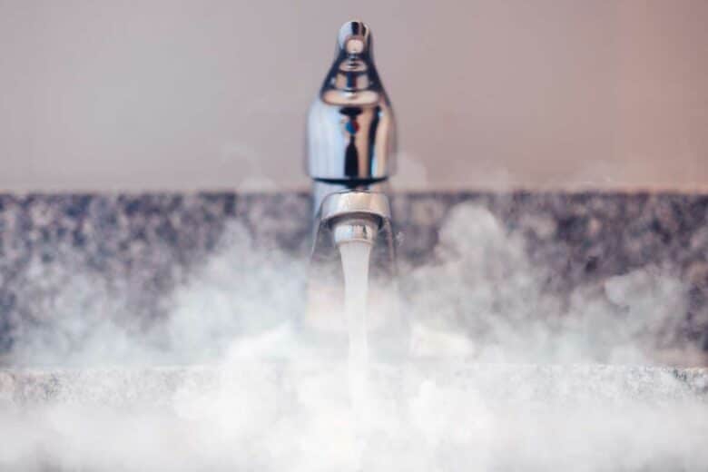 De l'eau chaude coule d'un robinet.