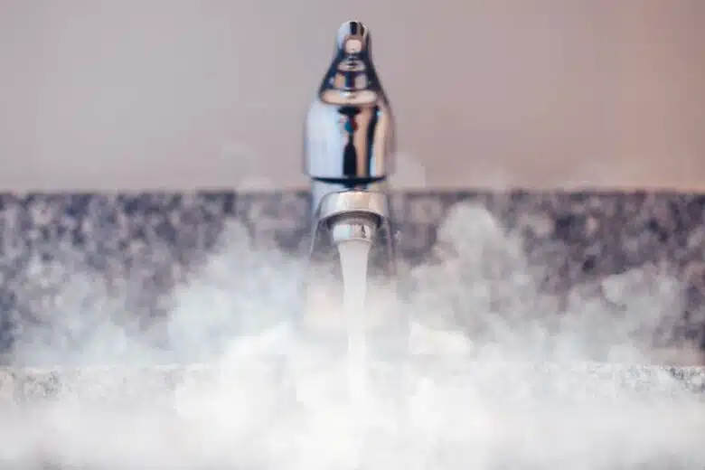 De l'eau chaude coule d'un robinet.