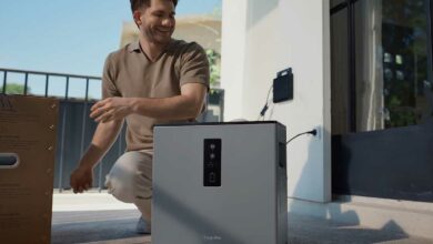 Un homme installe une batterie résidentielle.