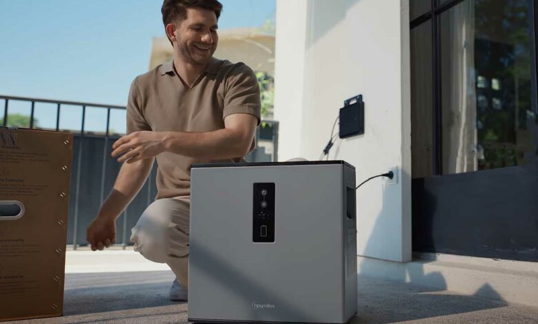 Un homme installe une batterie résidentielle.