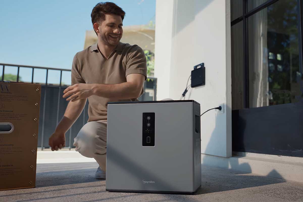 Un homme installe une batterie résidentielle.