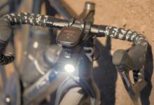 Une dashcam éclairante sur le guidon d'un vélo tombé au sol.