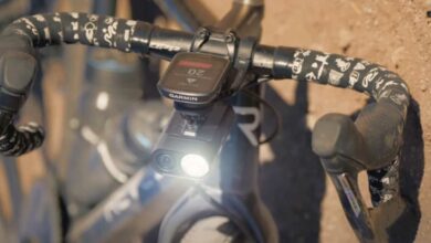 Une dashcam éclairante sur le guidon d'un vélo tombé au sol.