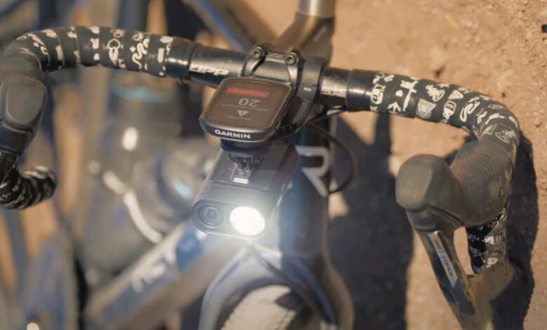 Une dashcam éclairante sur le guidon d'un vélo tombé au sol.