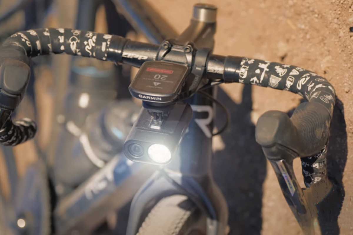 Une dashcam éclairante sur le guidon d'un vélo tombé au sol.