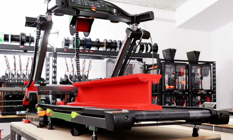 Une imprimante 3D montée sur un tapis de course.