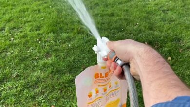 Une personne entretient sa pelouse avec un engrais Bleen.