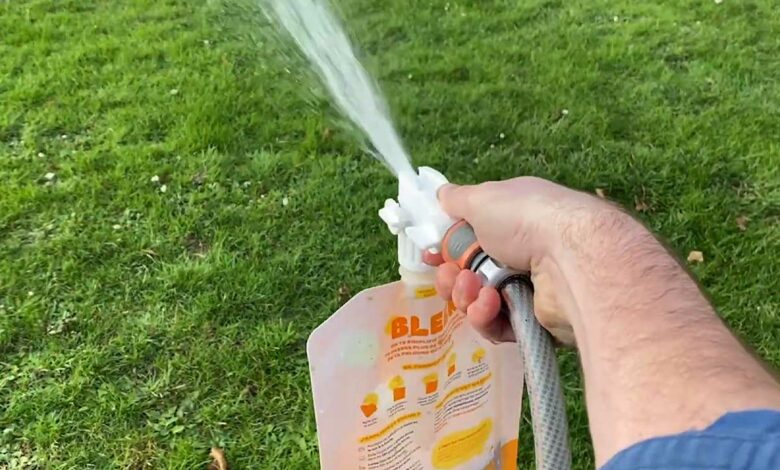 Une personne entretient sa pelouse avec un engrais Bleen.