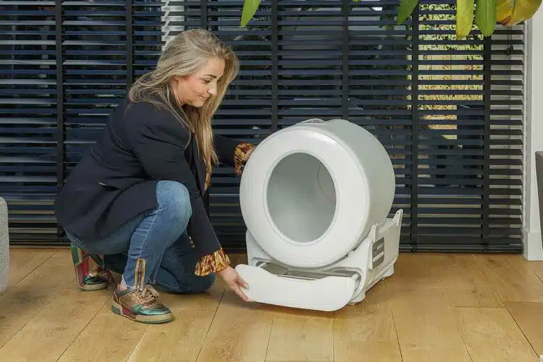 Une femme retire le panier à déchets de la litière.