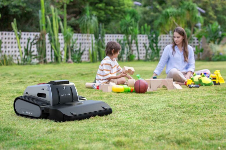 Un robot tondeuse s'occupe du jardin pendant que des enfants jouent.