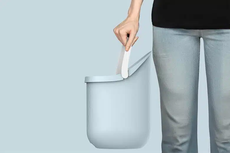 Une personne tient un seau d'eau par son anse.