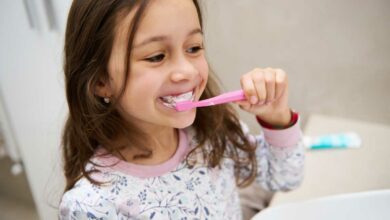 Une petite fille se brosse les dents.
