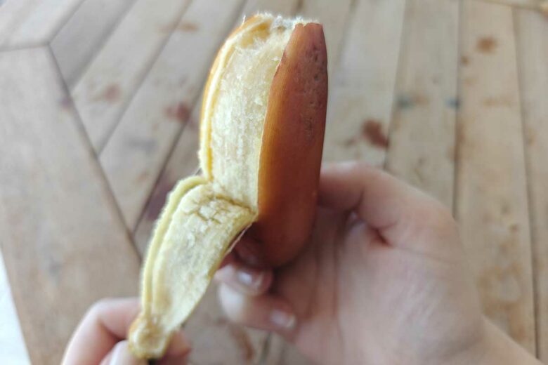Épluchage d'une banane rouge.