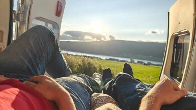 Des personnes contemplent le paysage dans leur van aménagé.