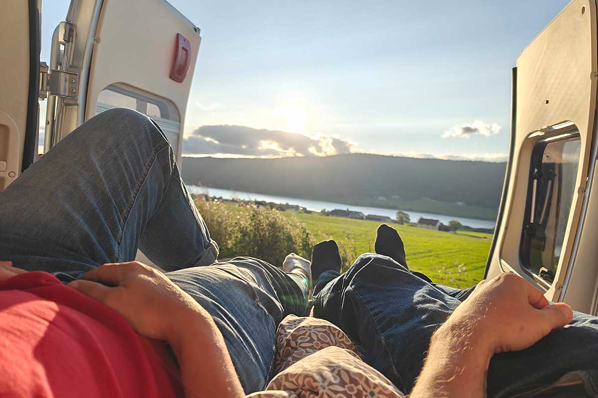 Des personnes contemplent le paysage dans leur van aménagé.