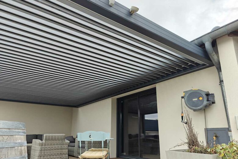Une pergola montée le long d'une maison.