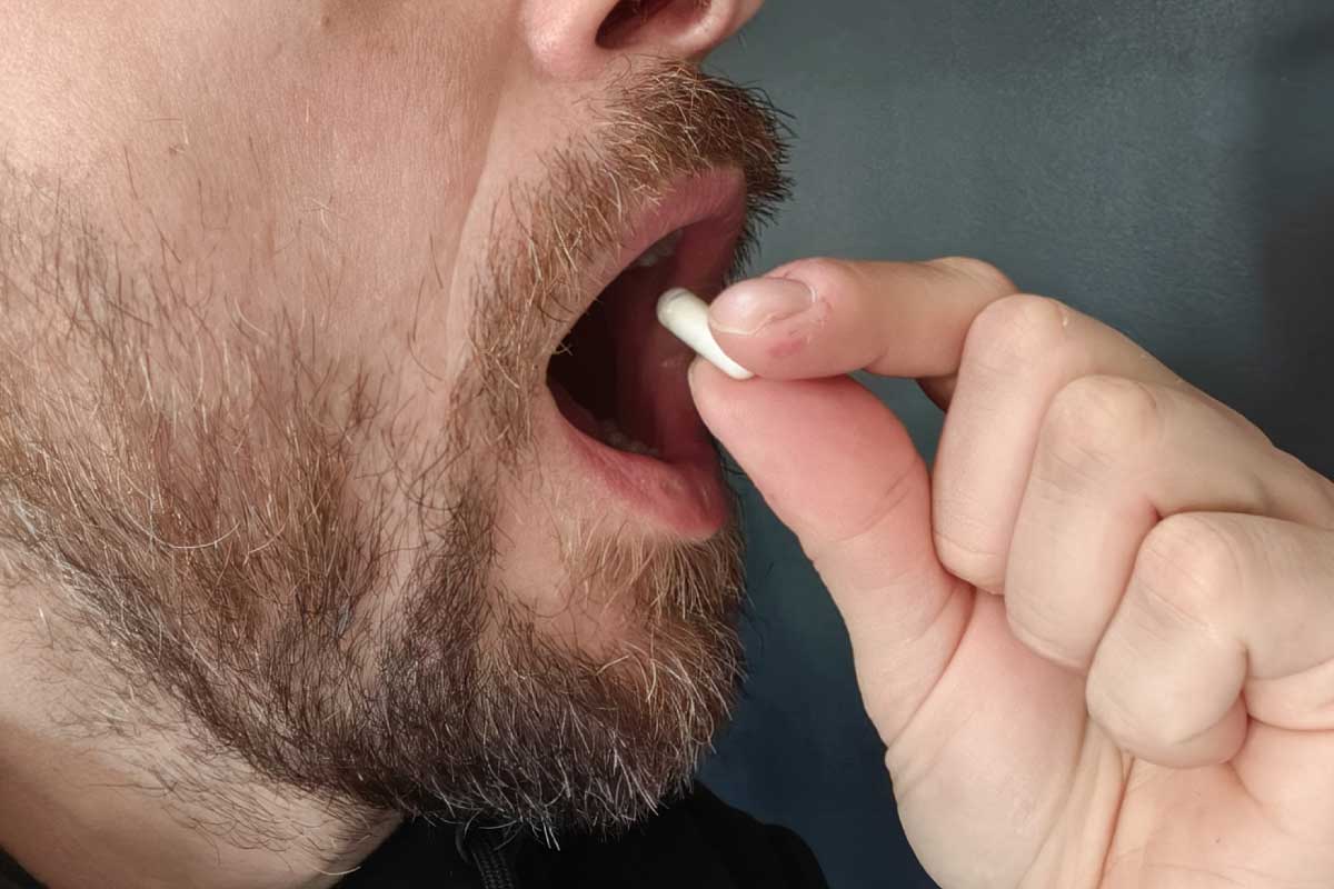 Un homme prend une gellule.