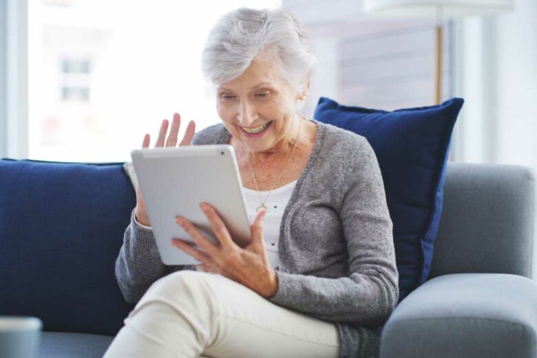 Une personne âgée fait une visio sur sa tablette.