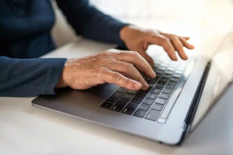 Une personne âgée utilise un ordinateur portable.