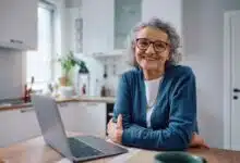Une personne âgée devant son ordinateur.