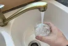 Une personne se verse un verre d'eau du robinet.