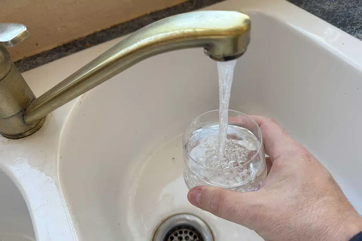 Une personne se verse un verre d'eau du robinet.