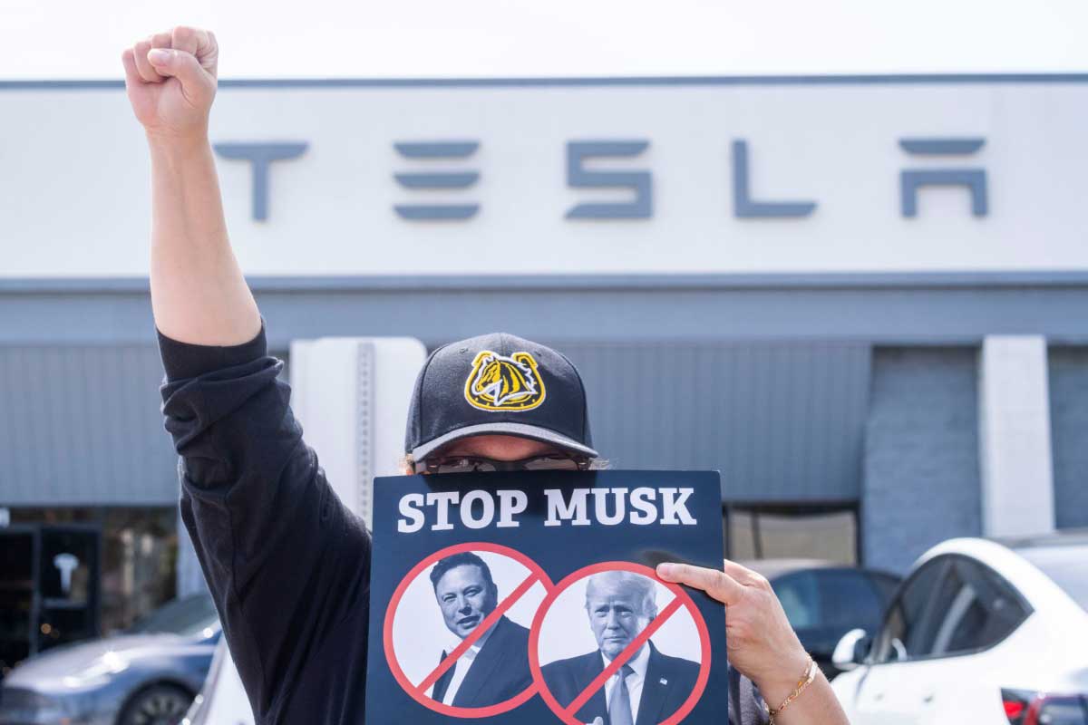 Un manifestant appelle au boycott de Musk et de Tesla.