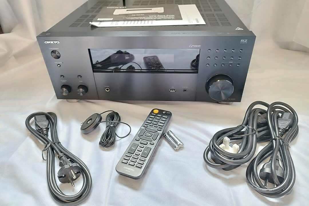 Vue d'ensemble du contenu du colis de l'ampli home-cinéma Onkyo TX-RZ30 : câbles, télécommande et micro de calibration.