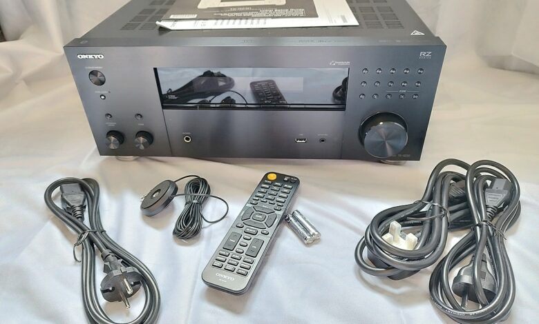 Vue d'ensemble du contenu du colis de l'ampli home-cinéma Onkyo TX-RZ30 : câbles, télécommande et micro de calibration.